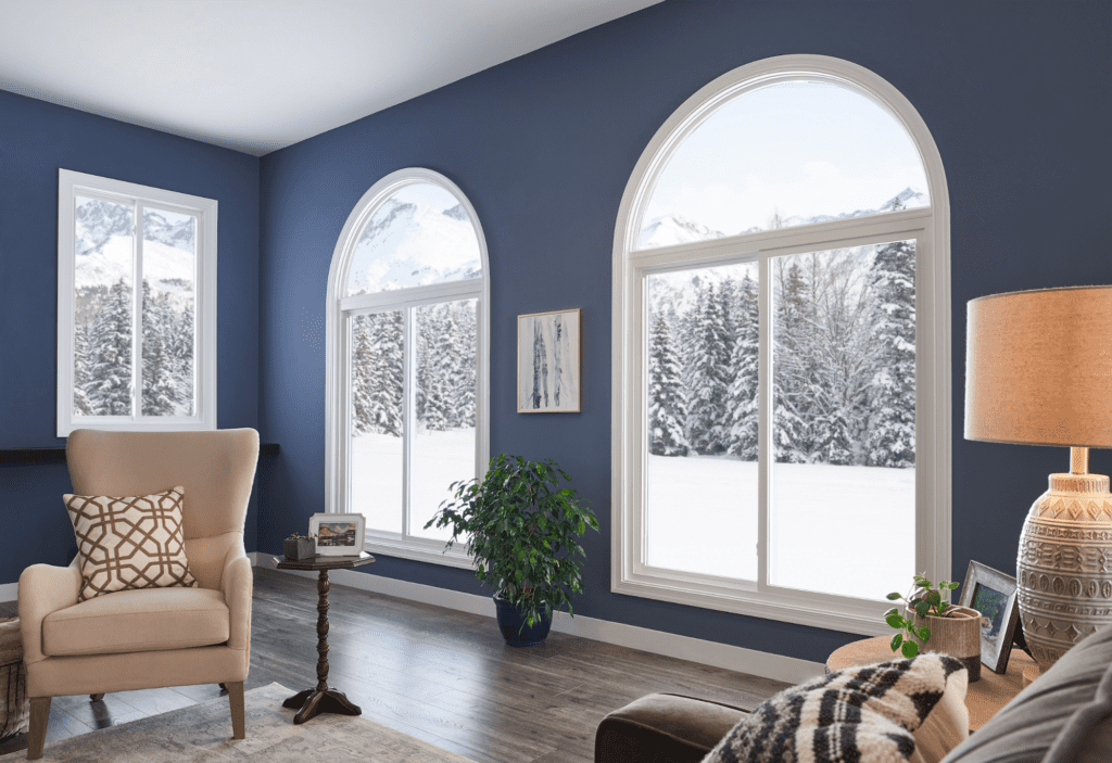 Two large sliding windows overlooking a snow-covered lawn. 