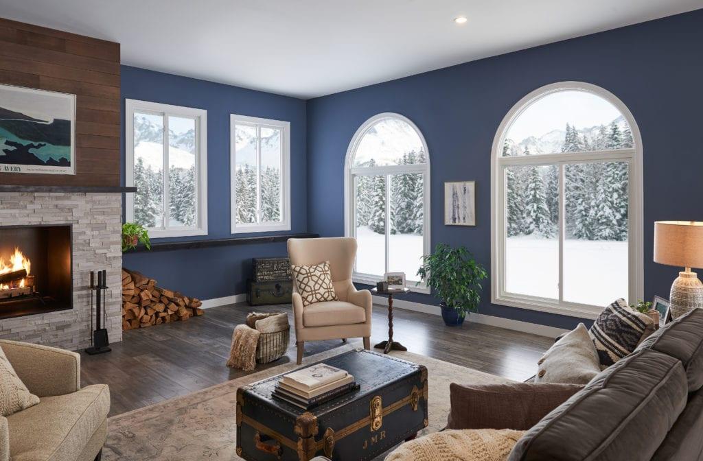 A indigo blue living room with a fireplace, overstuffed couch and comfortable chairs. 